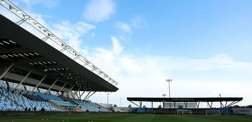 Joie Stadium with empty stands and clear sky