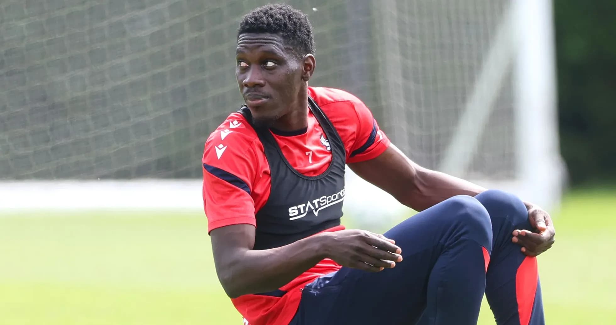 Player stretching during training session on pitch