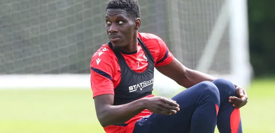 Player stretching during training session on pitch