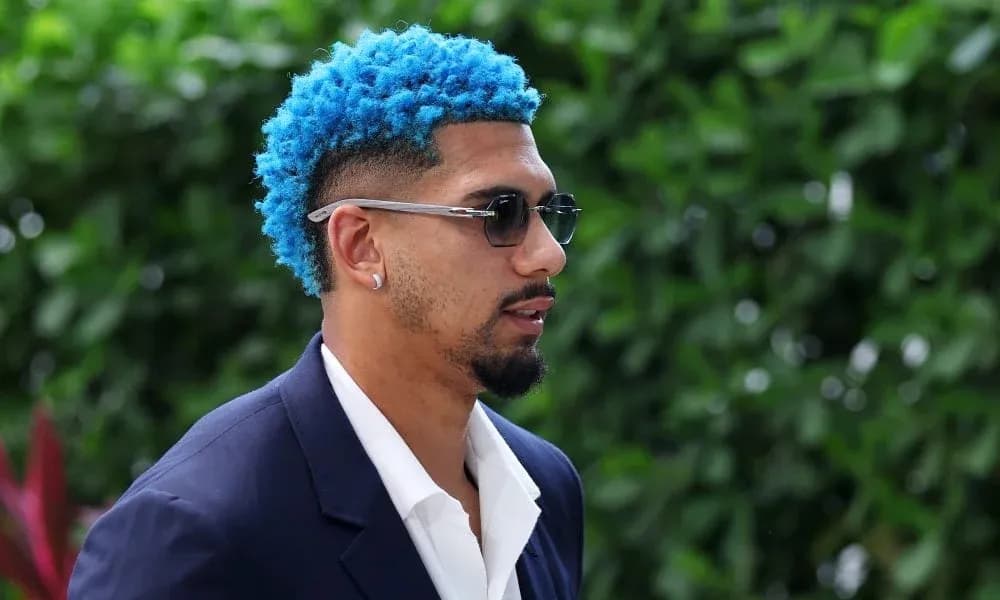 Man with blue hair wearing sunglasses and suit