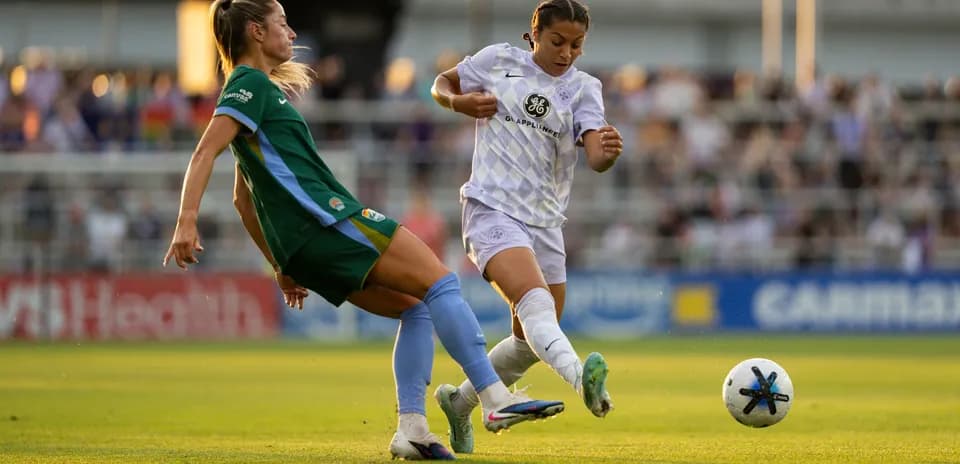 Two players competing for the ball in NWSL match