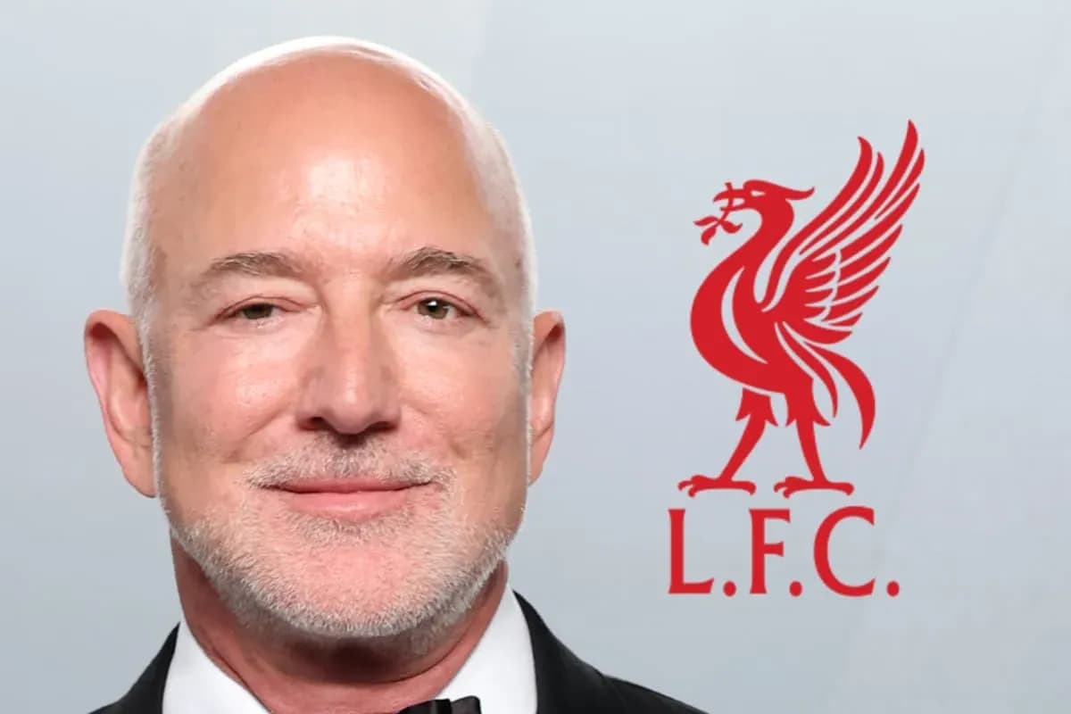 Man smiling with Liverpool FC logo in background
