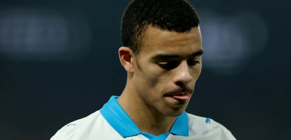Player in white jersey looking down thoughtfully
