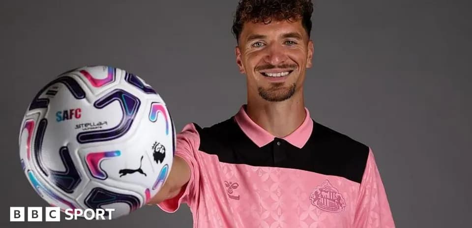 Player holding a football, wearing pink kit