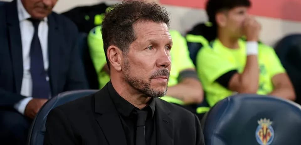 Coach seated on bench during match with players