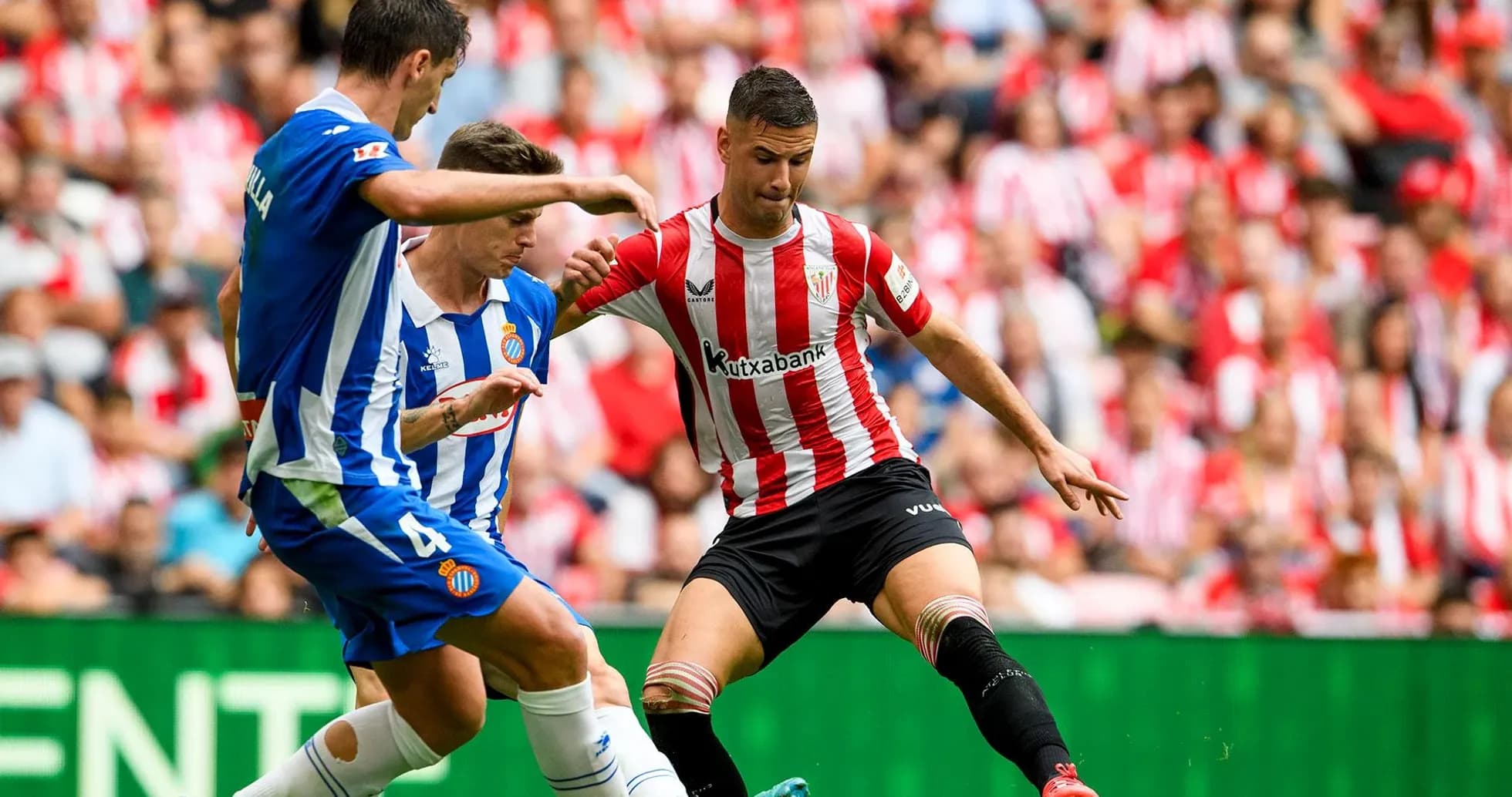 Espanyol players challenging Athletic Club opponent