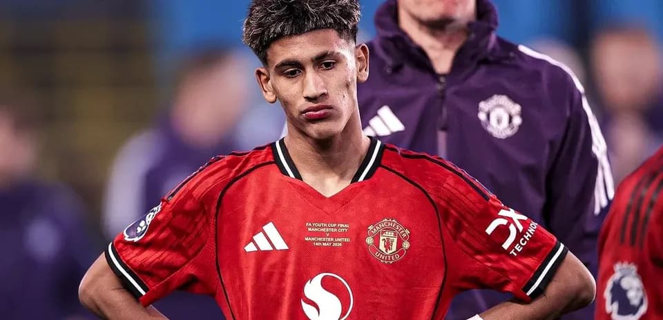 Young player in Manchester United jersey looking down