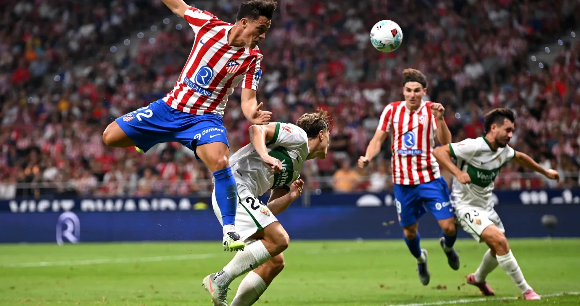 Atletico Madrid player tackling Elche opponent