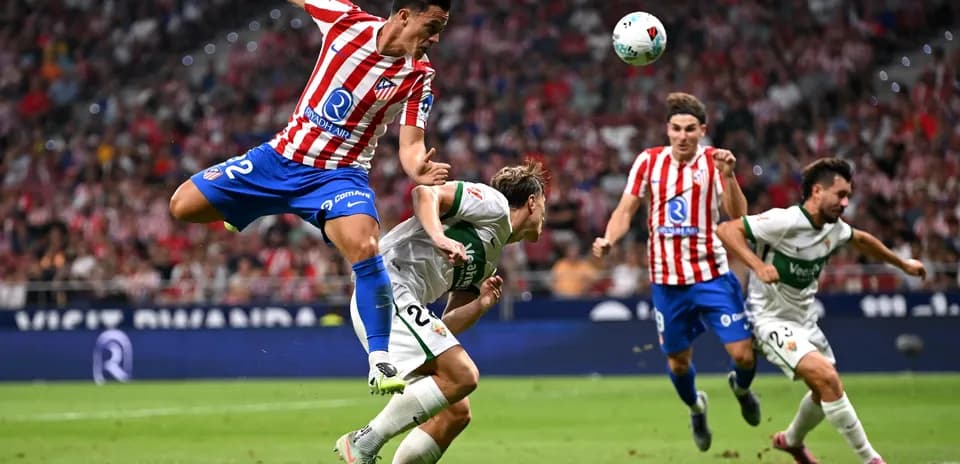 Atletico Madrid player tackling Elche opponent