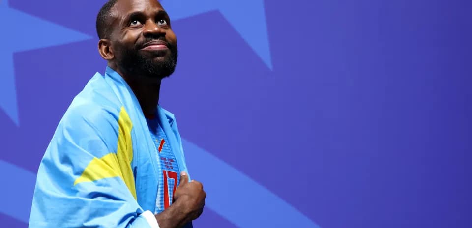Athlete wearing national flag, smiling during event