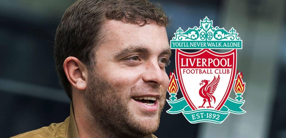 Person smiling beside Liverpool FC club logo