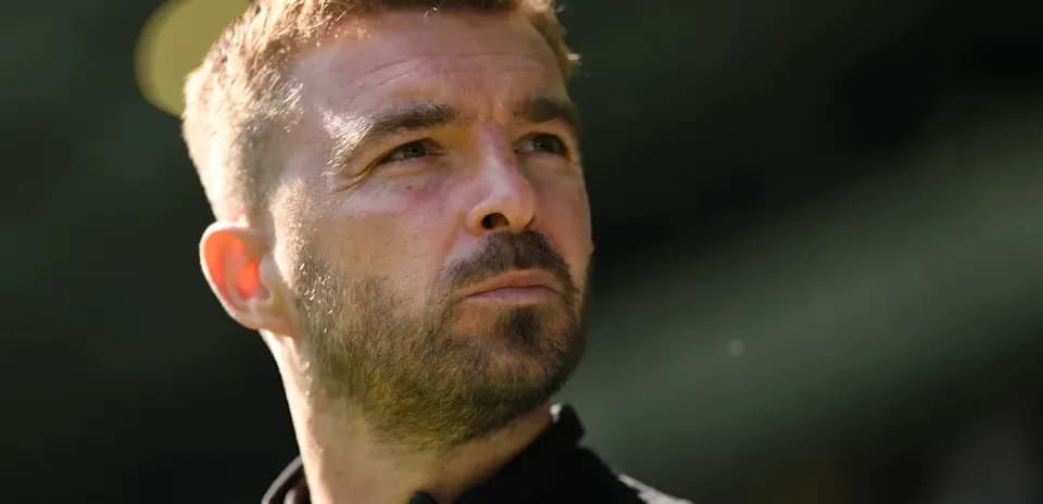 Man in black shirt looking thoughtfully off-camera