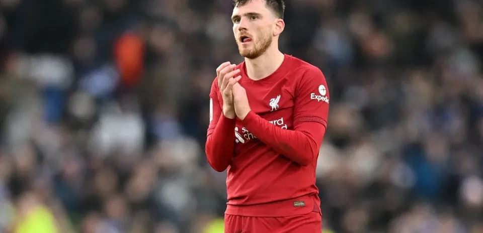 Player in Liverpool kit applauding fans after match