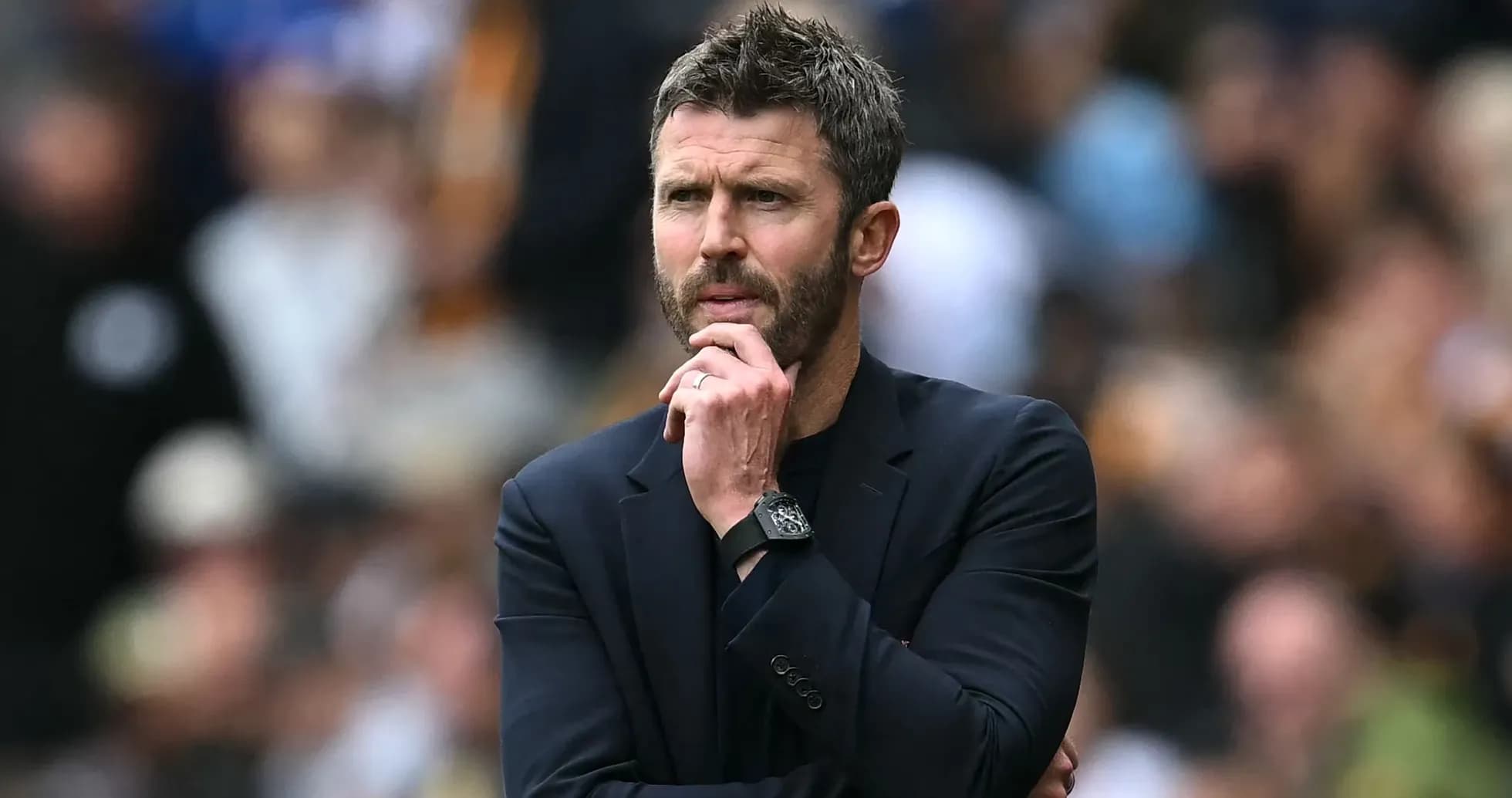 Coach observing match while deep in thought