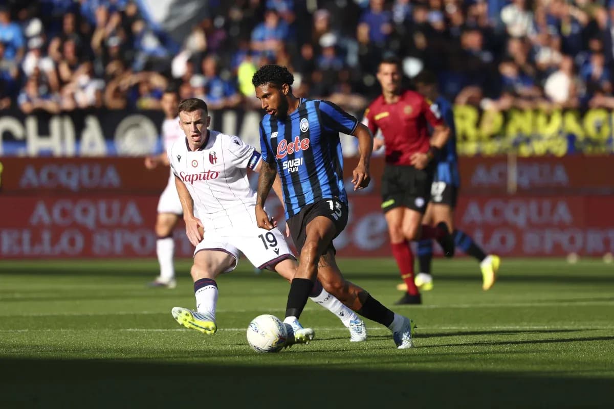 Atalanta player dribbling against Bologna defender