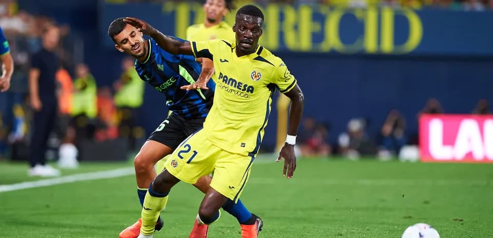 Villarreal player dribbling past opponent during match