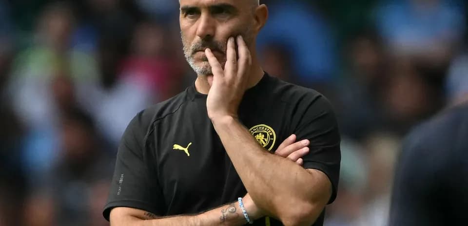 Manager observing the match with thoughtful expression