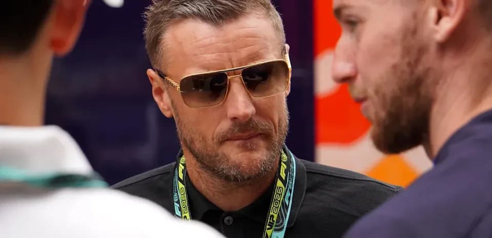 Man in sunglasses conversing with two others