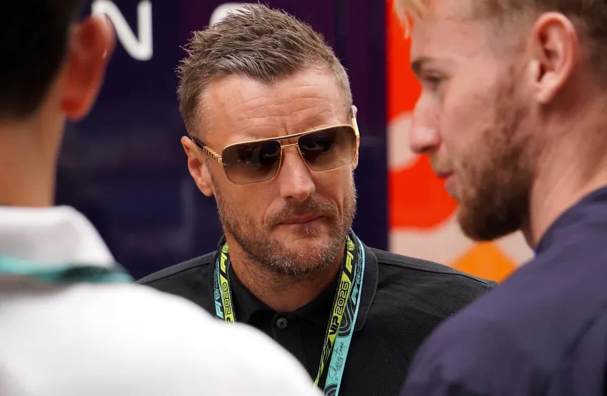 Man in sunglasses conversing with two others
