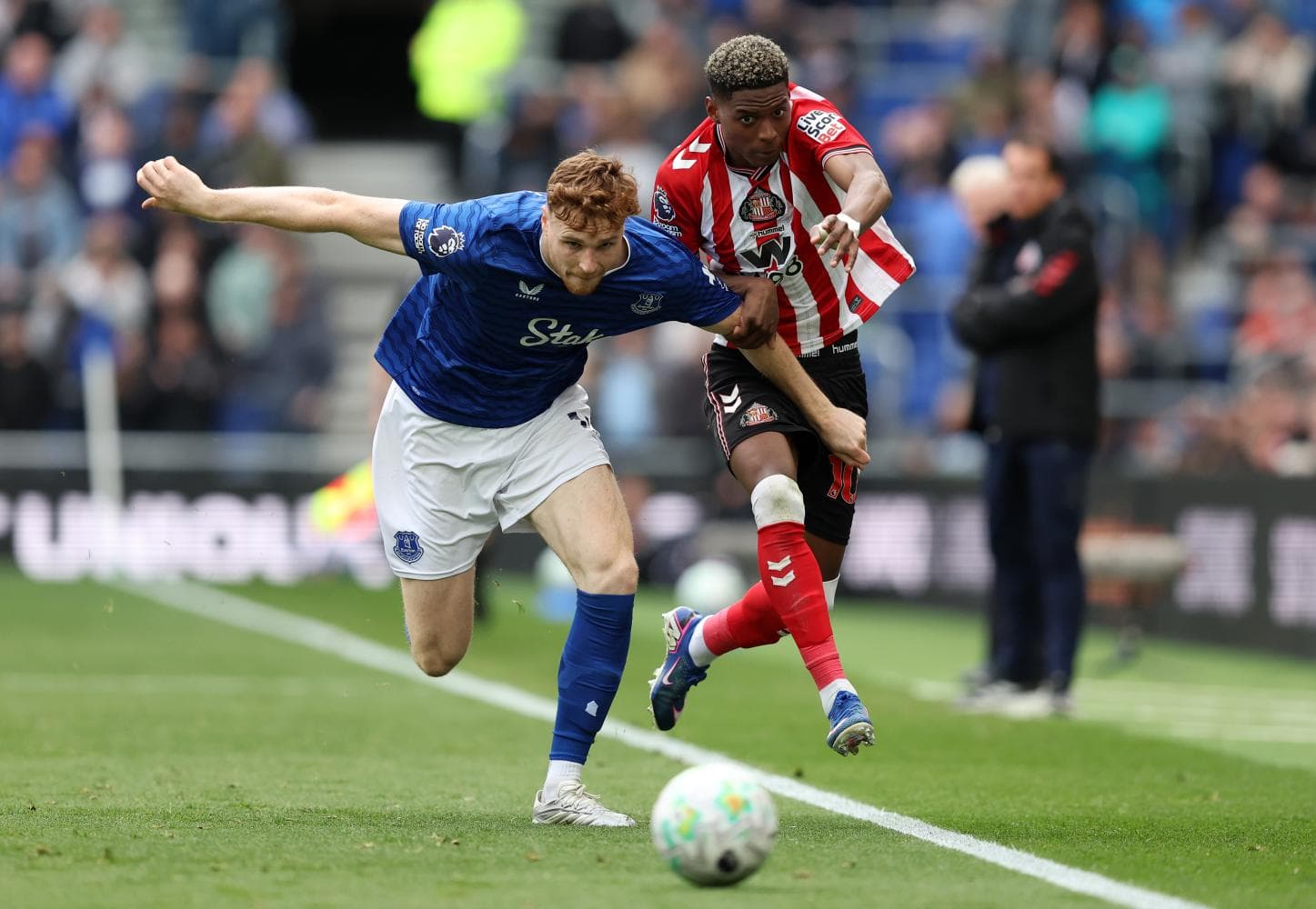 Everton player challenging Sunderland opponent for ball