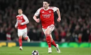 Arsenal player sprinting towards the ball during match