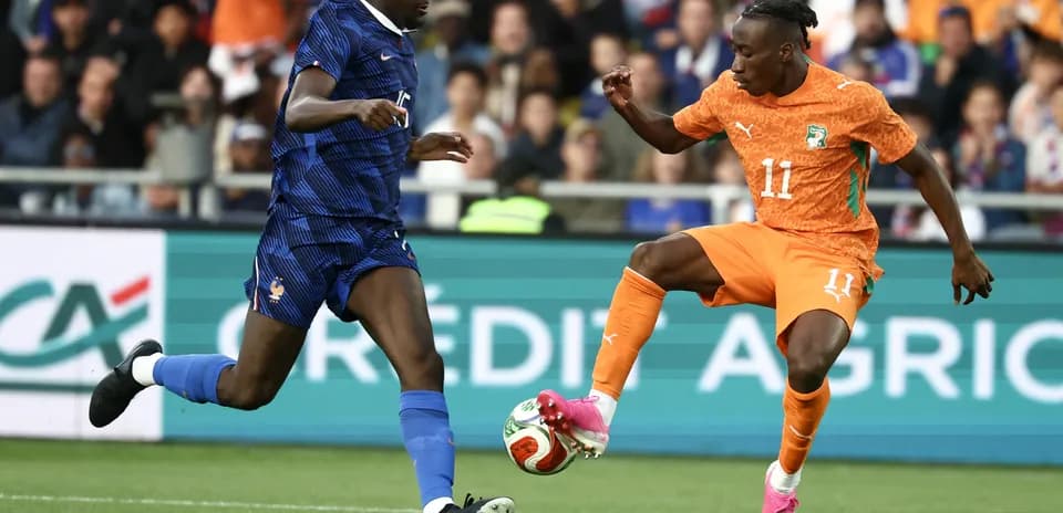 Player dribbling past opponent during football match