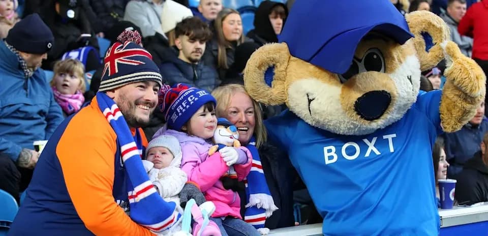 Family posing with mascot at sporting event