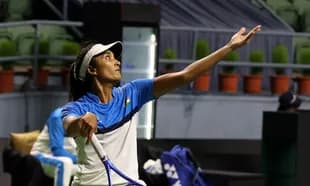 Female tennis player serving during practice session