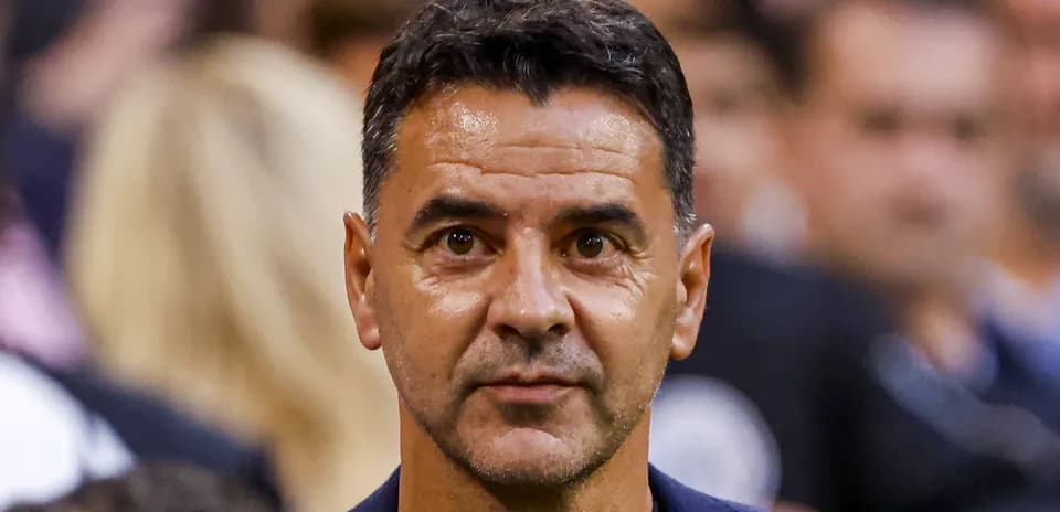 Man in suit at sports event, focused expression