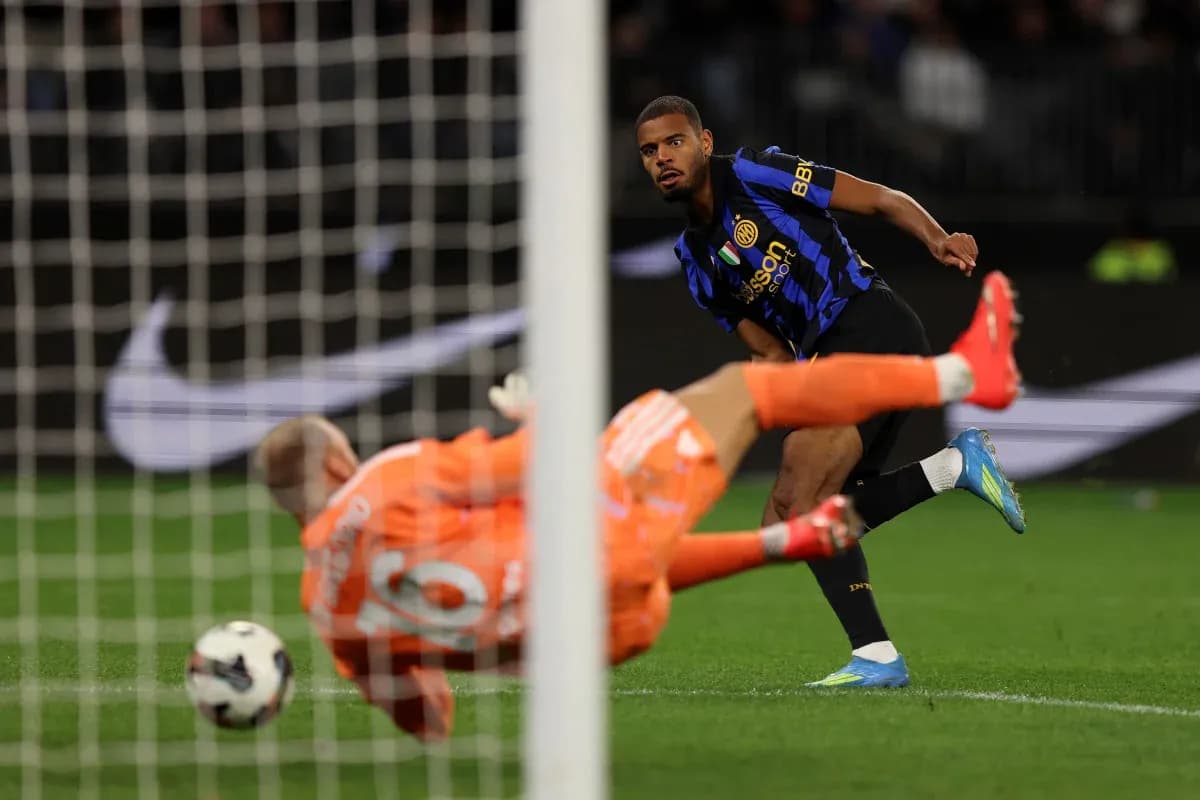 Player kicking the ball past the goalkeeper
