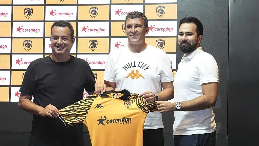 New coach holding Hull City jersey at presentation