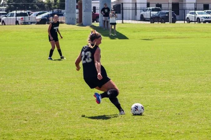 Player kicking soccer ball during practice session
