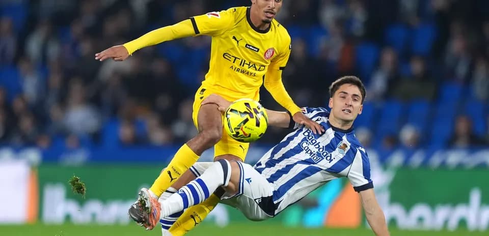 Girona player tackling Real Sociedad opponent