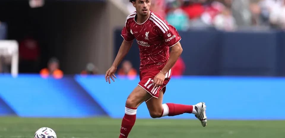 Player in red Liverpool kit running with ball