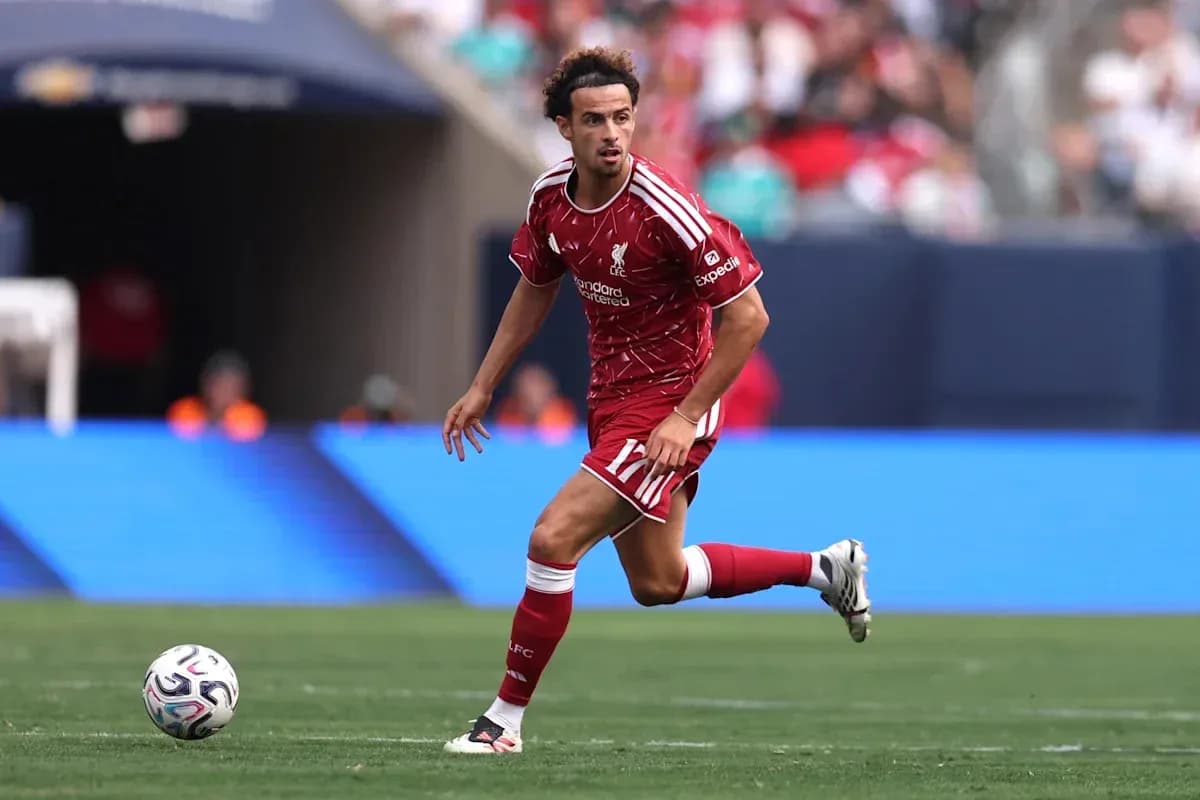 Player in red Liverpool kit running with ball