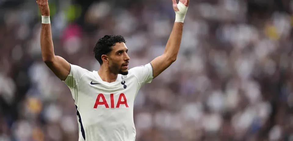 Player gesturing during match wearing Tottenham jersey