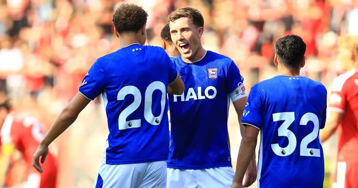 Three players celebrating in blue jerseys on field