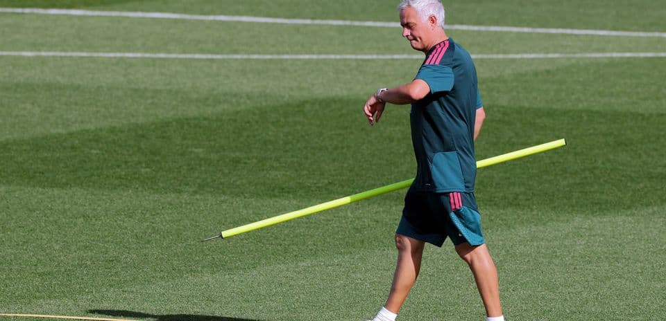 Coach walking with training pole on field
