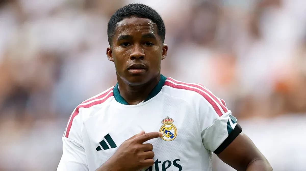 Player pointing to Real Madrid club badge on jersey