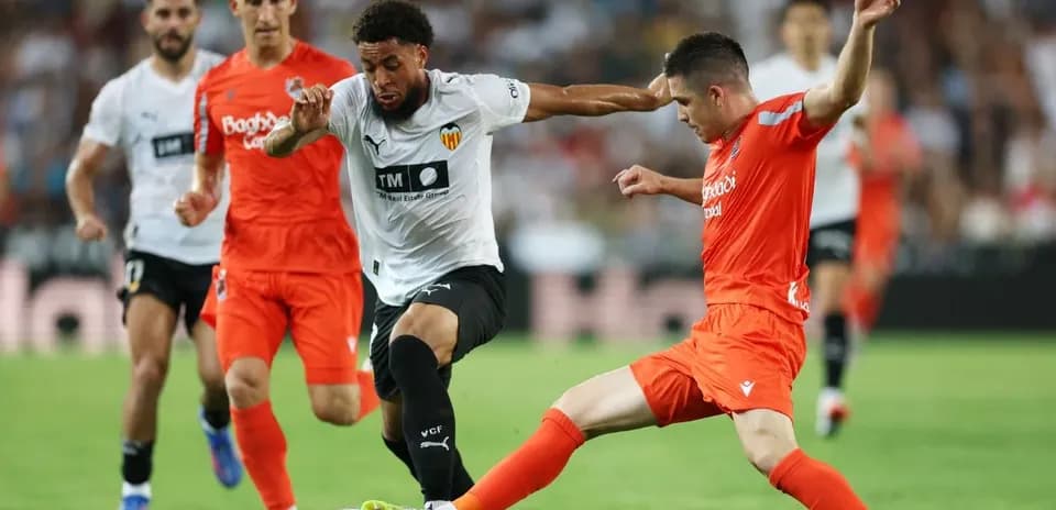 Real Sociedad players challenging Valencia opponent