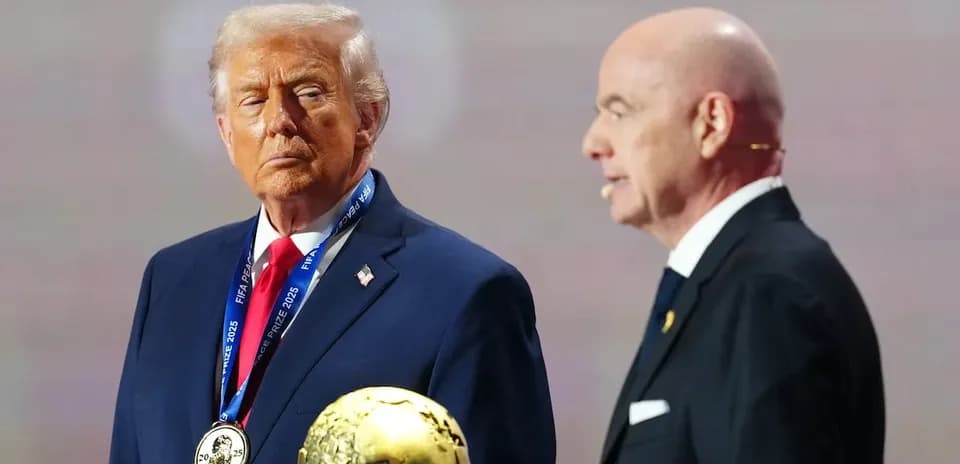 Two men on stage with FIFA award trophy