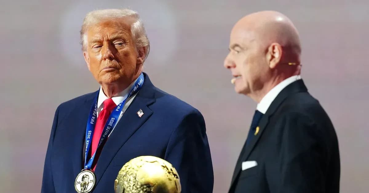 Two men on stage with FIFA award trophy