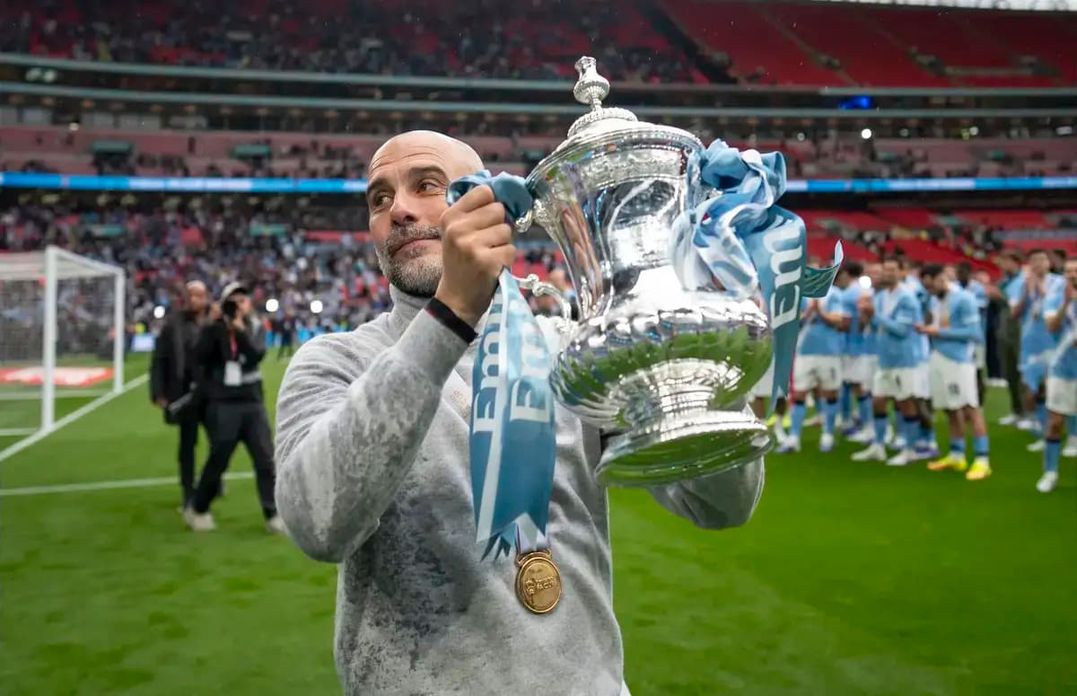 Manager holding trophy with team celebrating behind