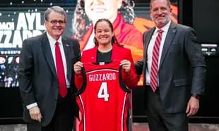 New coach Aylia Guzzardo holding jersey at introduction