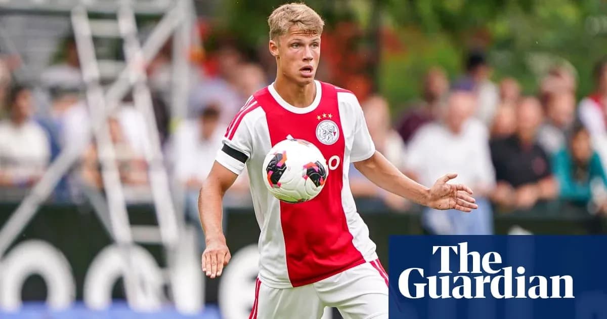 Player in Ajax kit controlling the ball during match