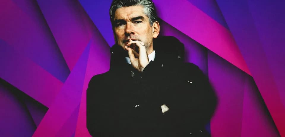 Man in a black coat with a thoughtful expression