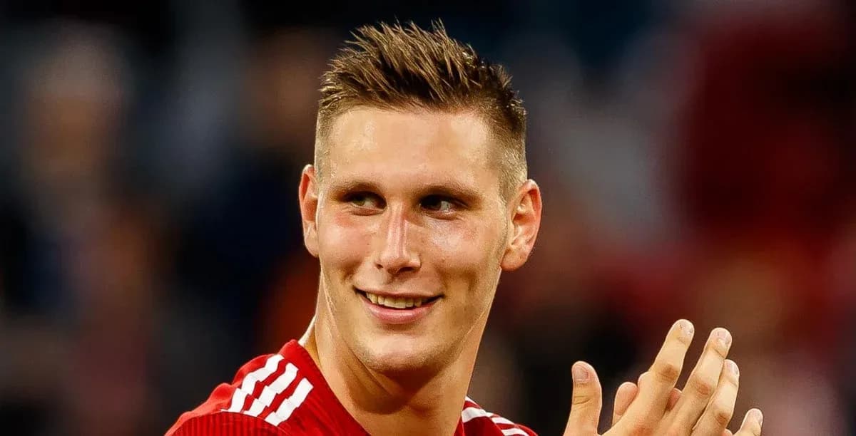 Player in red jersey smiling and applauding fans