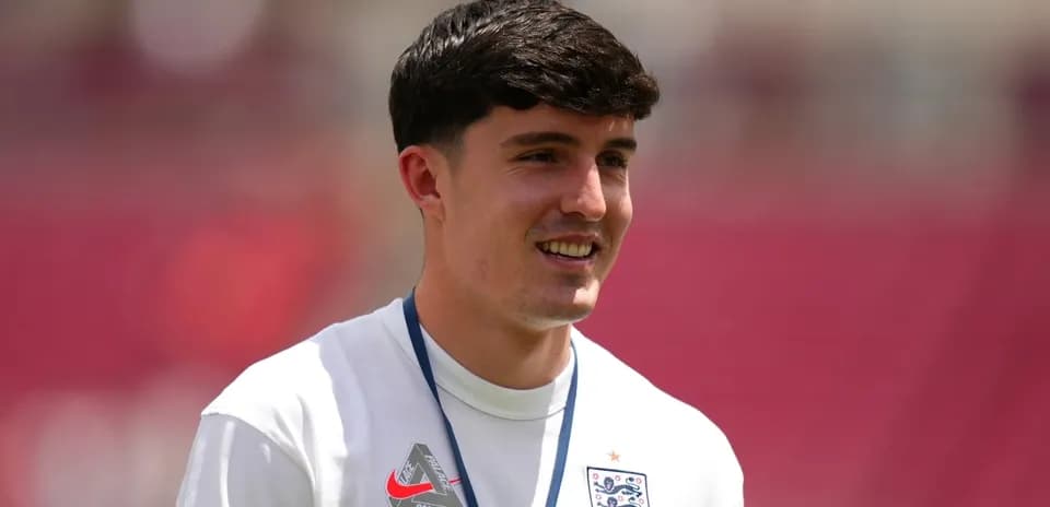 Player in England training kit smiling on pitch