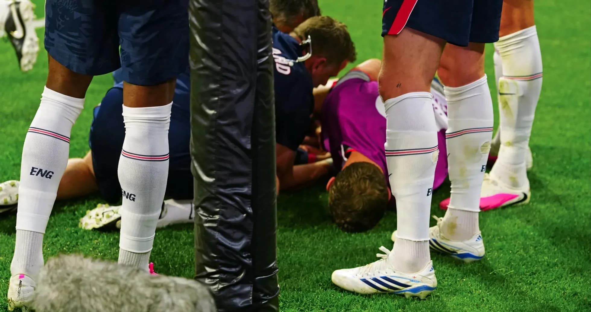 Players gathered around an injured teammate on field