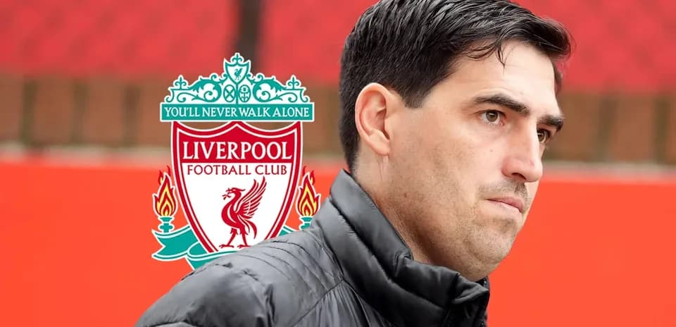 Manager standing near Liverpool FC logo background